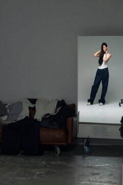 Person standing in studio mirror reflection modeling fashion