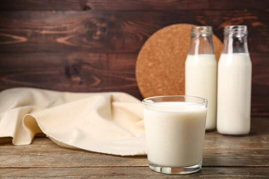 Glass of fresh milk on wooden background