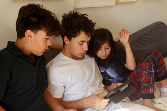 Siblings with tablet on sunny living room