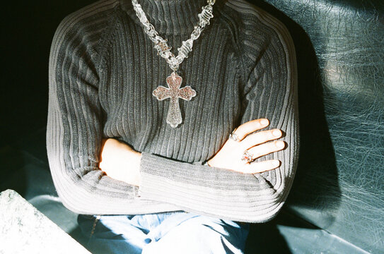 Person Wearing Necklace Sitting With Arms Crossed