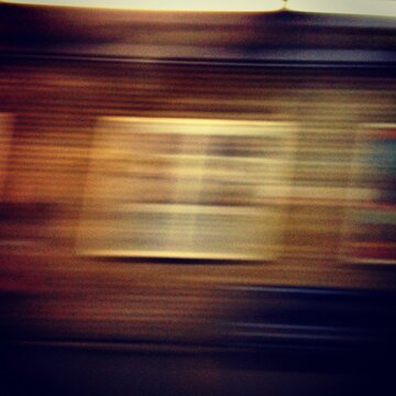 Motion blurred view from a train showing a brick wall and window