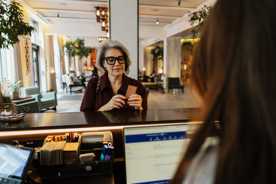 Guest receiving key card at hotel reception counter
