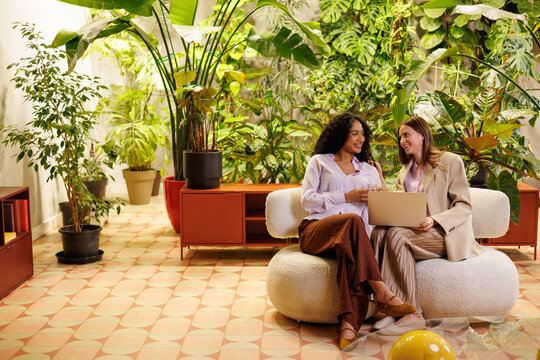 Women collaborating on business ideas with laptop in indoor garden