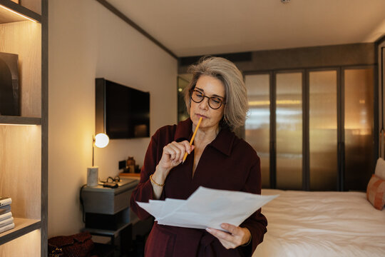 Business owner analyzing documents in home office
