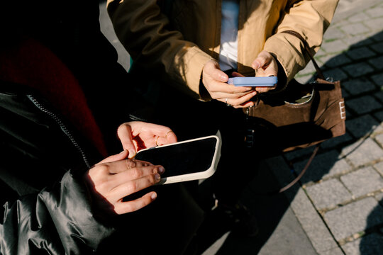 Anonymous women using their smartphones on the streets of Paris