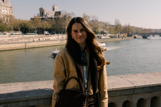 Portrait of female tourist looking at camera posing at the Seine River
