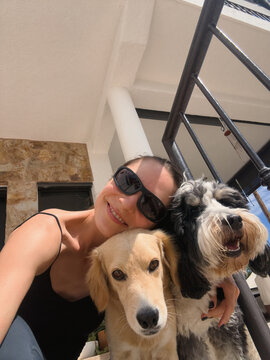 selfie of woman in sunglasses with two dogs