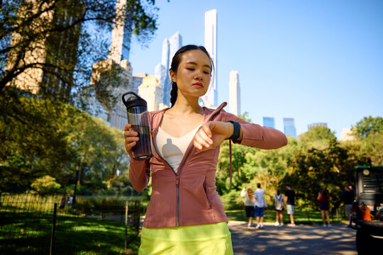 Sportswoman monitors her pace on her watch in Central Park