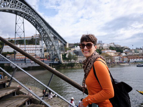 Woman smiling exploring Oporto city with the Douro River