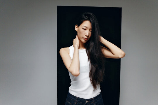 Person modeling white tank top and dark long hair