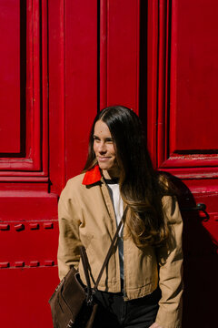 Woman posing in front of a red door on the streets of Paris
