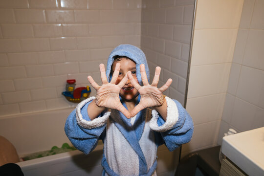 Happy kid showing wrinkled hands after bath time