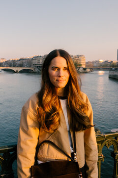 Waist-up portrait of a female tourist posing by the Seine River
