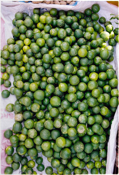 Gathering limes in a market stall during a sunny afternoon