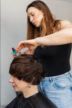 The hairdresser cuts hair