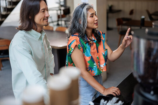 Couple ordering coffee at cafe counter together
