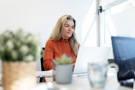 Businesswoman working online with laptop in modern office
