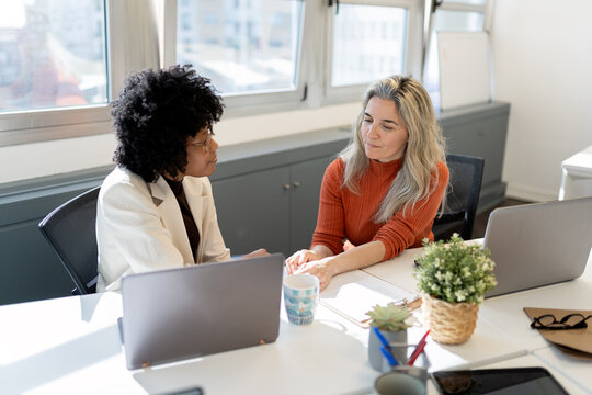Diverse women collaborating on business project in office