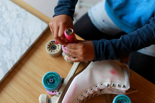 Child Changes Wheels on Roller Skates 