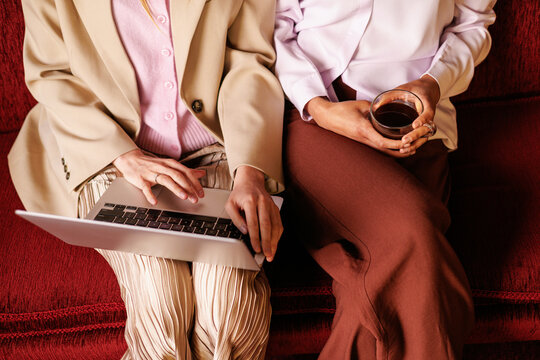 Business meeting with laptop and coffee on red sofa