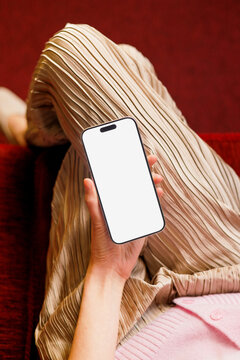Woman hand holding  Phone with white screen on red sofa mockup