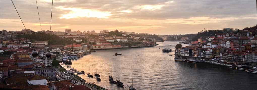Porto cityscape at sunset along Douro River with cable car
