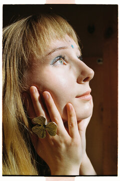 Girl poses with hands on her face looking on sunlight