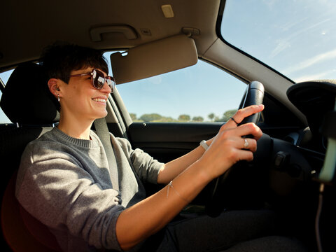 Woman in sunglasses driving car on a sunny day in Porto