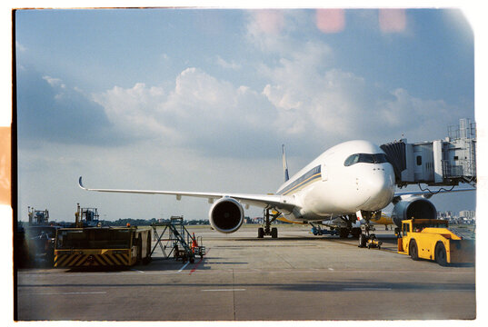 Large airplane parked at airport gate during sunny day