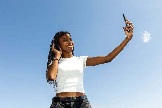Woman using smartphone over blue sky