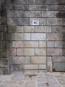 Hidden WC door blending into stone wall in Oporto