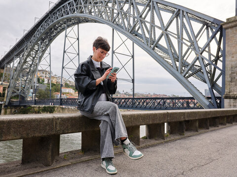 Woman using smartphone while exploring Oporto, Portugal