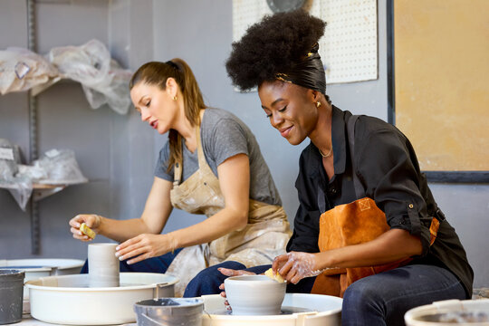 Two Women Shape Clay at a Pottery Studio