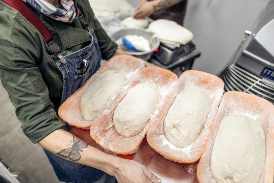 Baker carrying fresh bread dough for baking