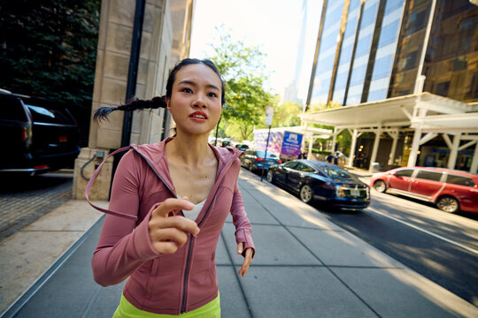 Sportswoman runs for exercise along the sidewalk in NYC