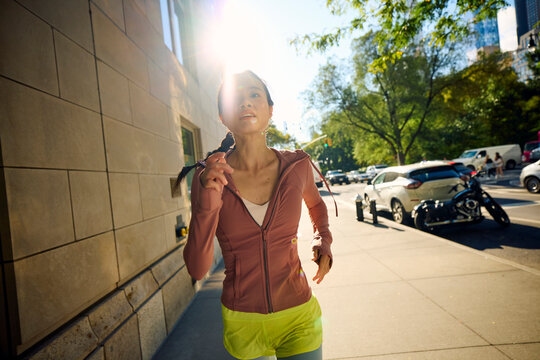 Sportswoman jogs on the NYC sidewalk for fitness