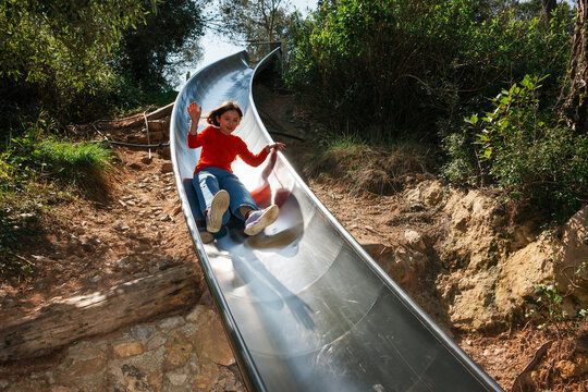 Joyful Ride on Outdoor Metal Slide in Forest