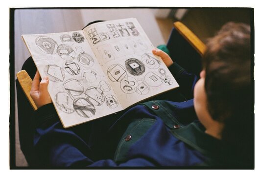 An artist looks at his sketches in a sketchbook