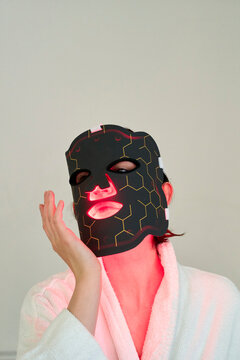Woman Uses a Skincare Mask With LED Lights for Treatment