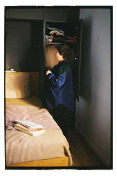 A woman gets dressed by the bed