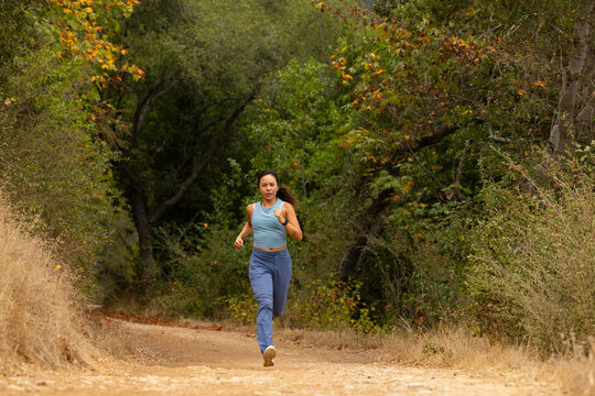 Determined Asian fitness woman athlete  running trail
