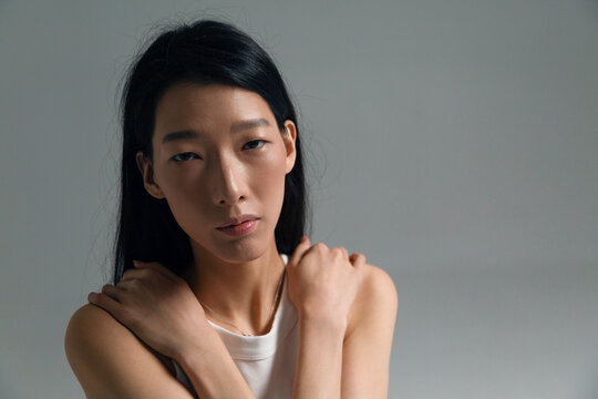 Person posing in white top with serious expression