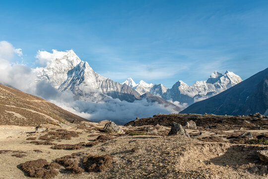 Snow covered Himalayan peaks rising above cloud filled valley