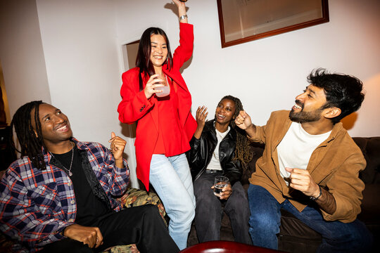 Friends hanging out at home party laughing and dancing