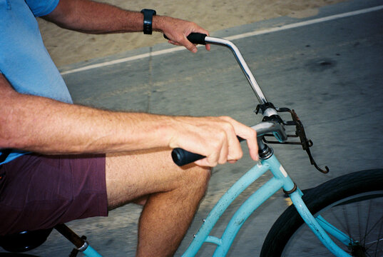 Anonymous man rides a blue bicycle in LA