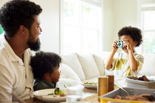 Son taking a picture of his father and brother