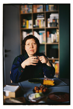 A woman enjoys a drink at a table.