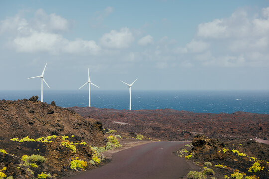 Wind turbines above volcanic coast road, La Palma island