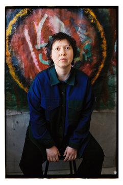 Portrait of a woman in front of her painting