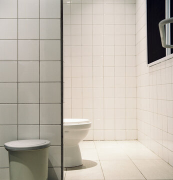 Restroom setting showing a toilet and waste bin